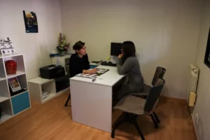 Conseillère funéraire en rendez-vous avec une cliente dans un bureau d'accueil.