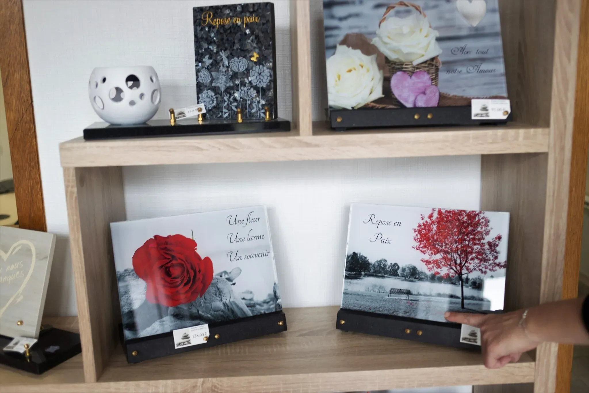Plaques souvenir personnalisées avec motifs et messages exposées sur une étagère.